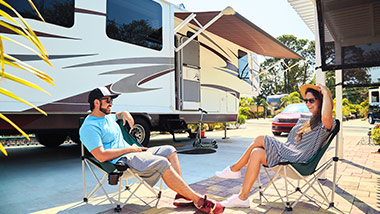 People sitting outside of a camper trailer